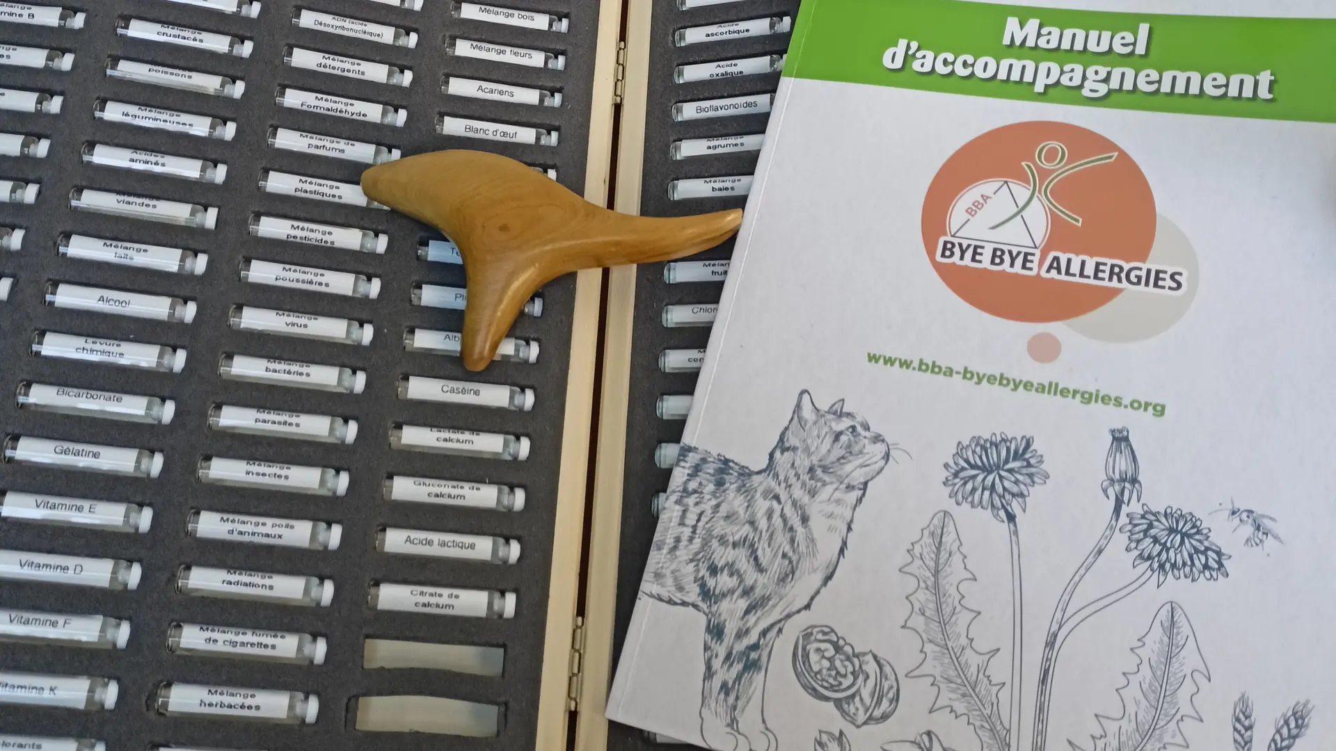 Des fioles présentent dans un trieur en bois.