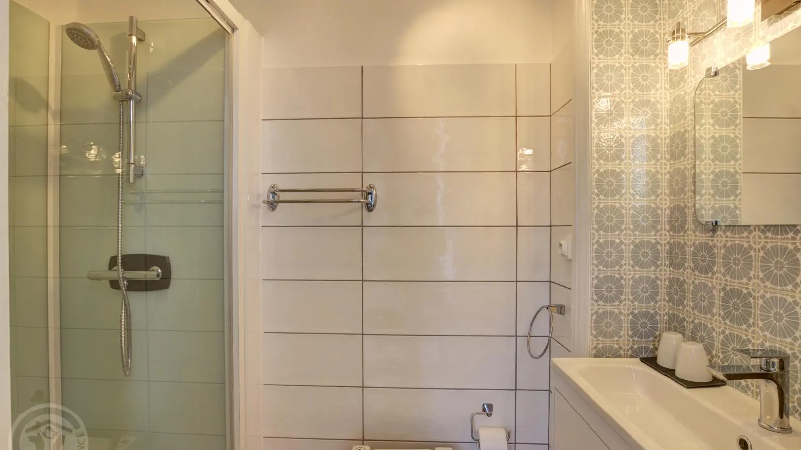 petite salle de bain avec douche et WC sanibroyeur.