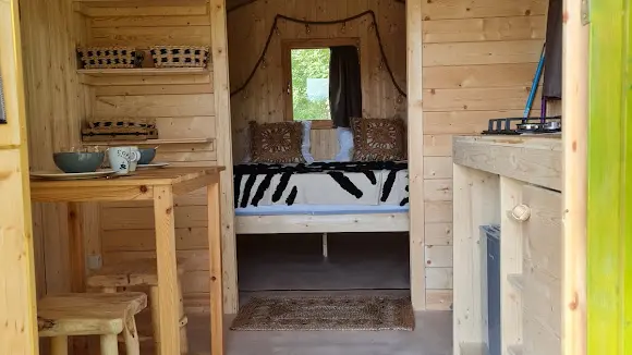 Roulotte de 11m² avec espace nuit et kitchenette : micro-ondes - 2 feux gaz - 1 petit frigo - un évier avec jerricane d'eau pouvant être remplie dans le bloc sanitaire.