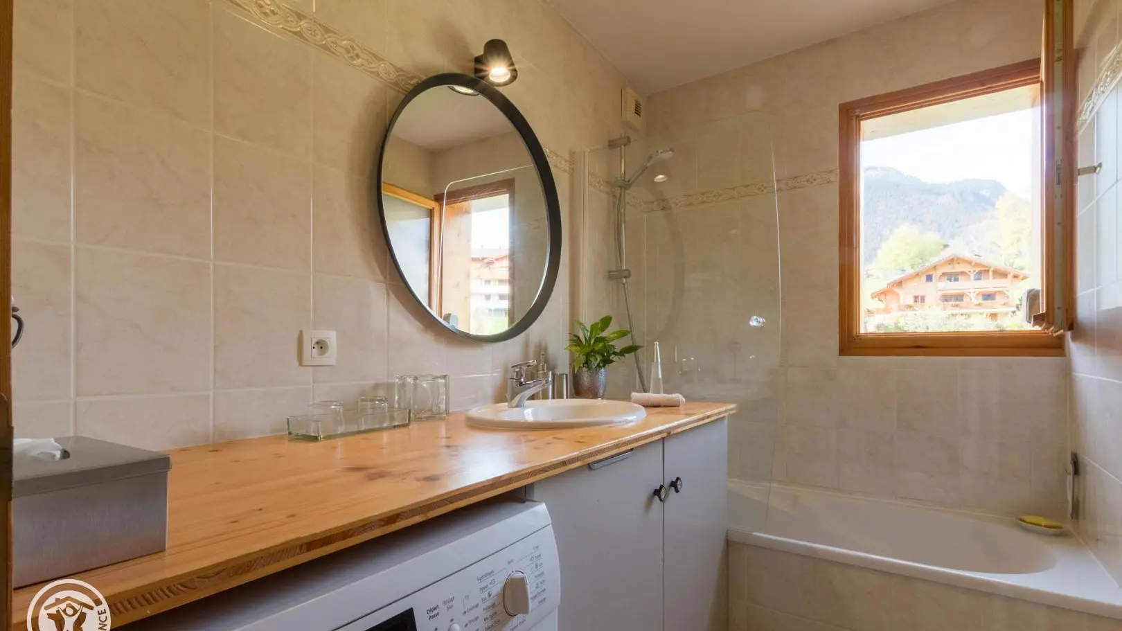 Salle de bain avec baignoire, vasque sur meuble, lave linge