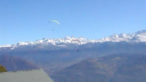 Vue sur la montagne et les parapentes depuis la terrasse