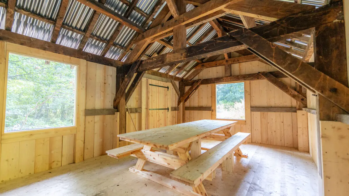 intérieur de la cabane à Baban avec une table de repas et des bancs