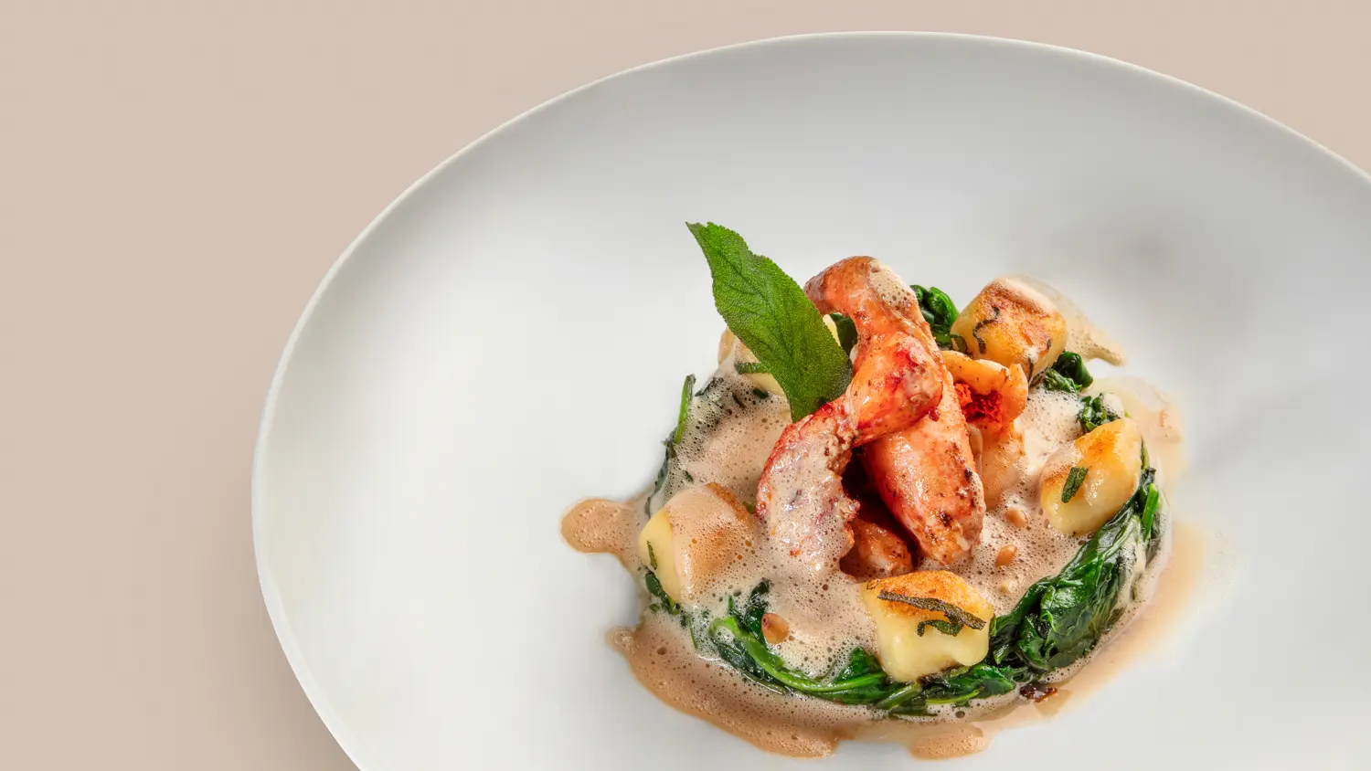 Demi homard snacké, jeunes pousses d'épinards, gnocchis et sauce vierge truffée