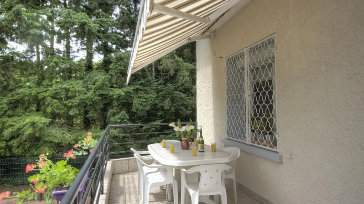 très large balcon donnant sur un pré avec des chevaux et la campagne environnante .