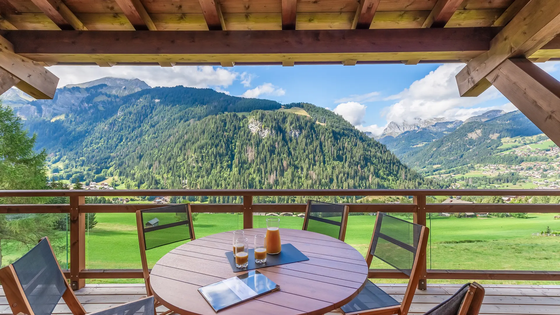 Terrasse couverte avec son mobilier et vue panoramique sur le village et les montagnes