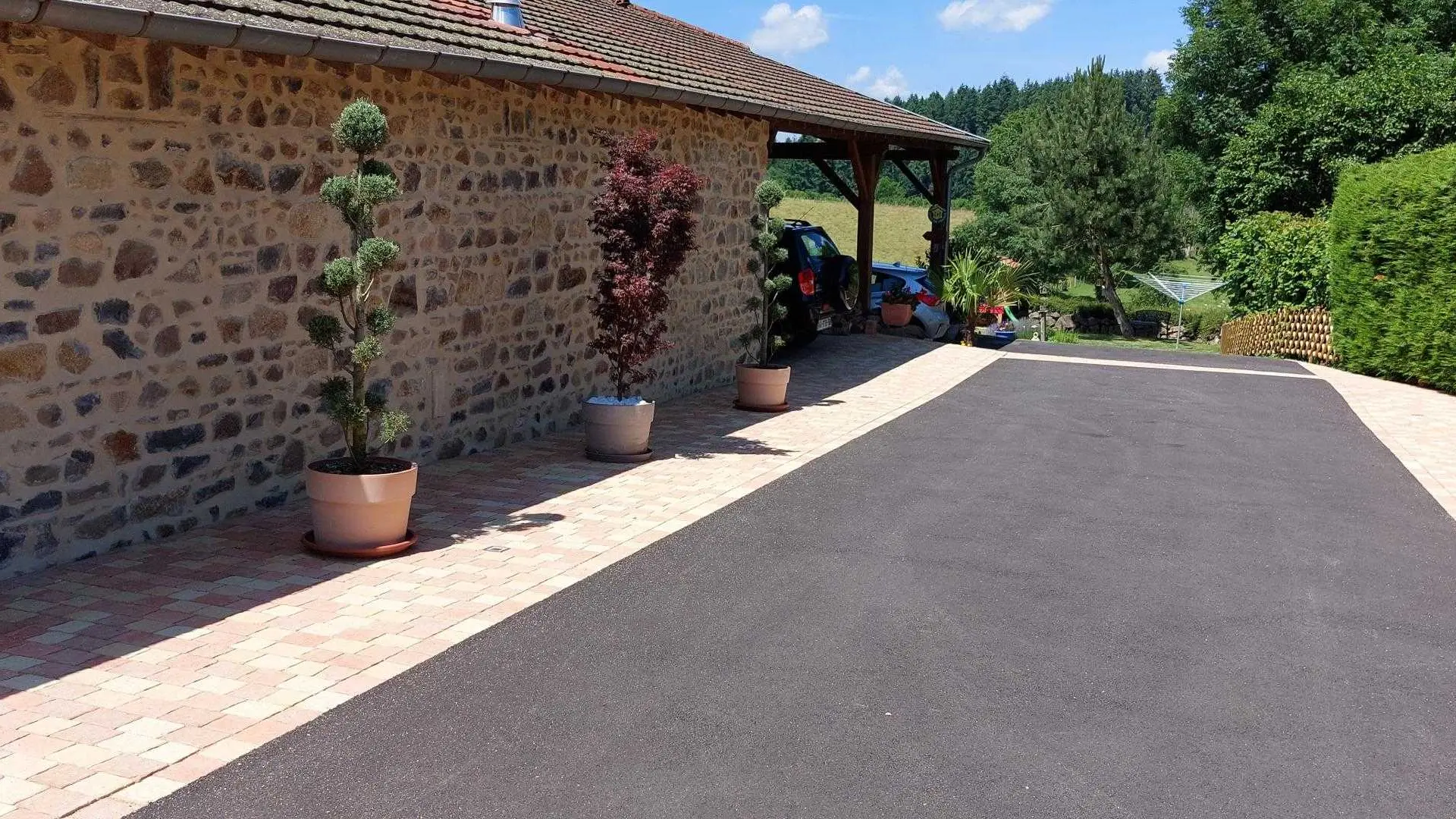 Entrée du parking avec abri couvert pour la voiture au fond juste devant le gîte
