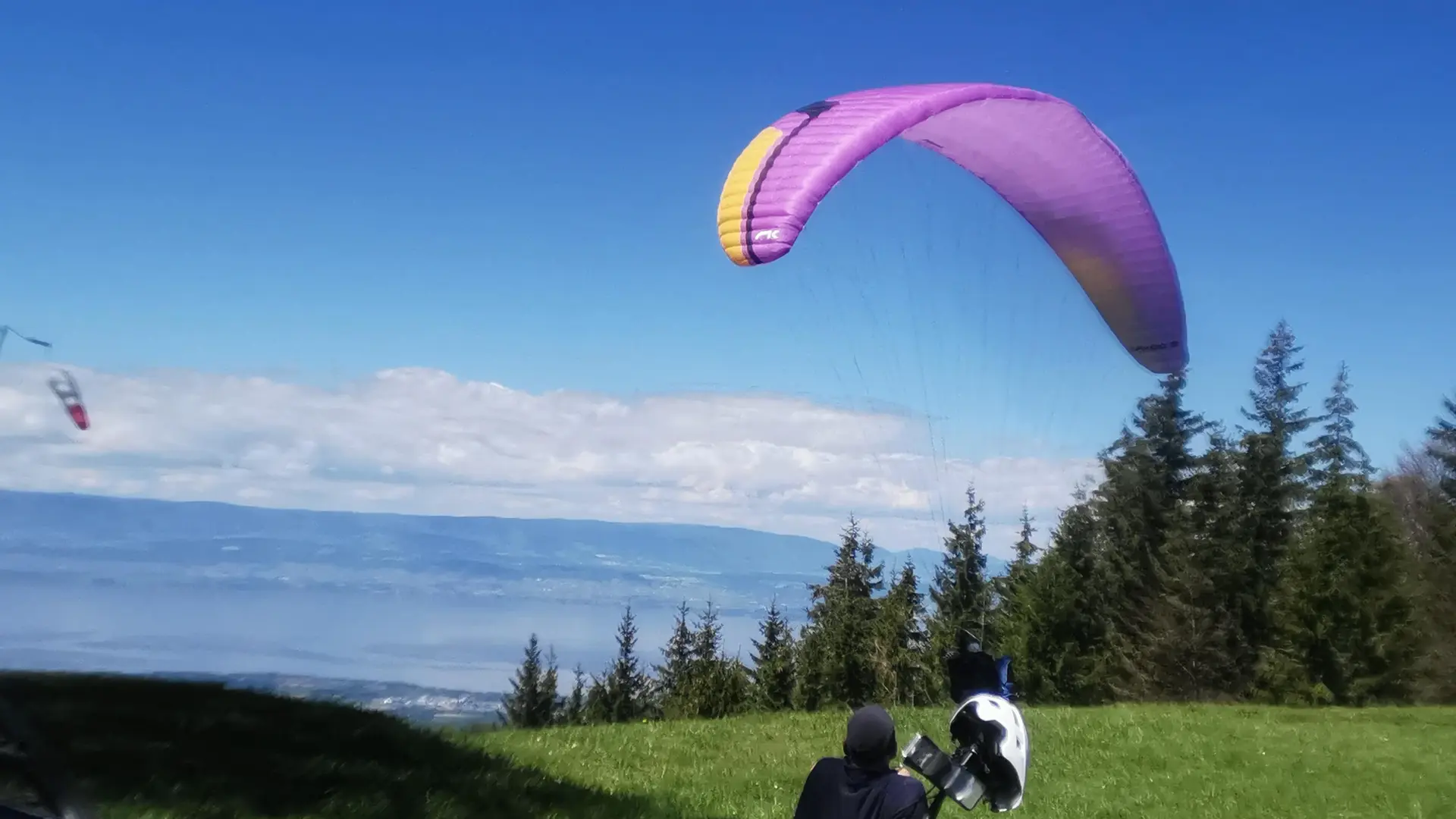 vtt et parapente sur l'aire de décollage avec vue sur le Léman