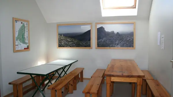 Espace salle à manger avec tables en bois dans la partie cuisine du Gîte des Hauts Plateaux