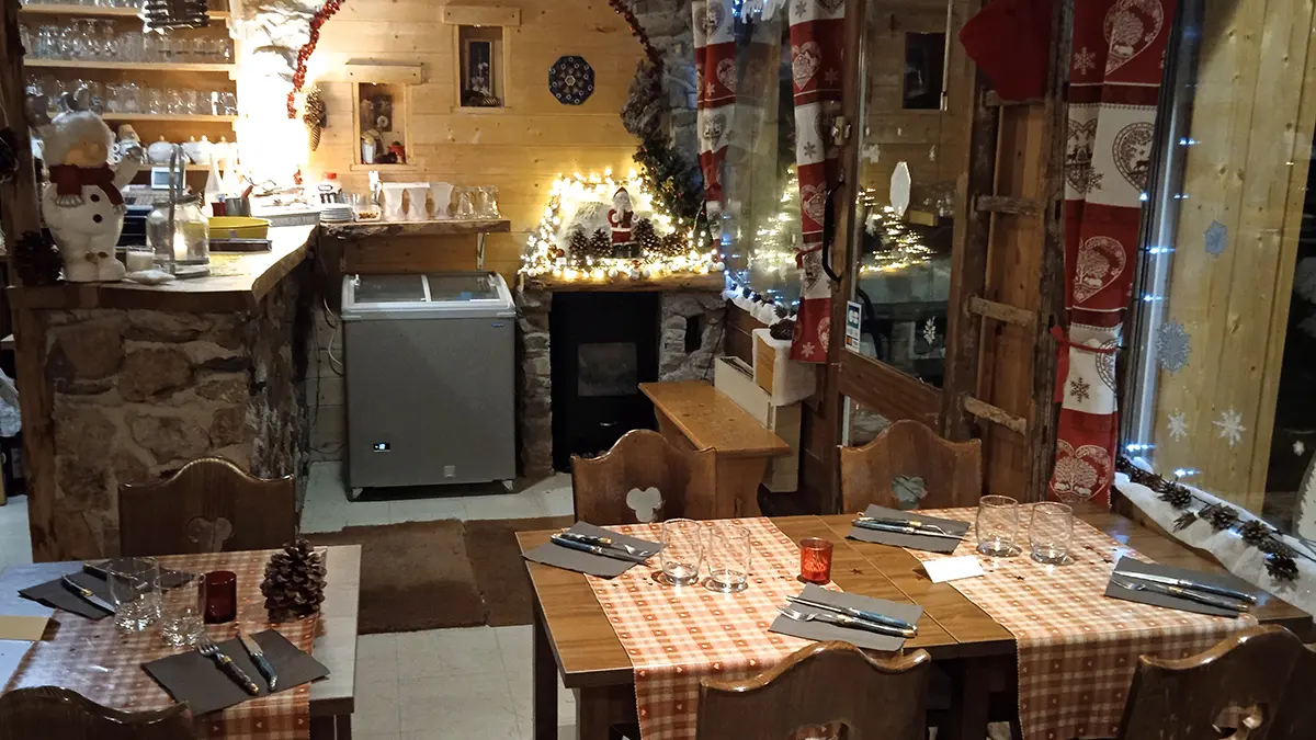 Intérieur de la crêperie, décoration de Noël, bois et pierre, tables à manger et chaises