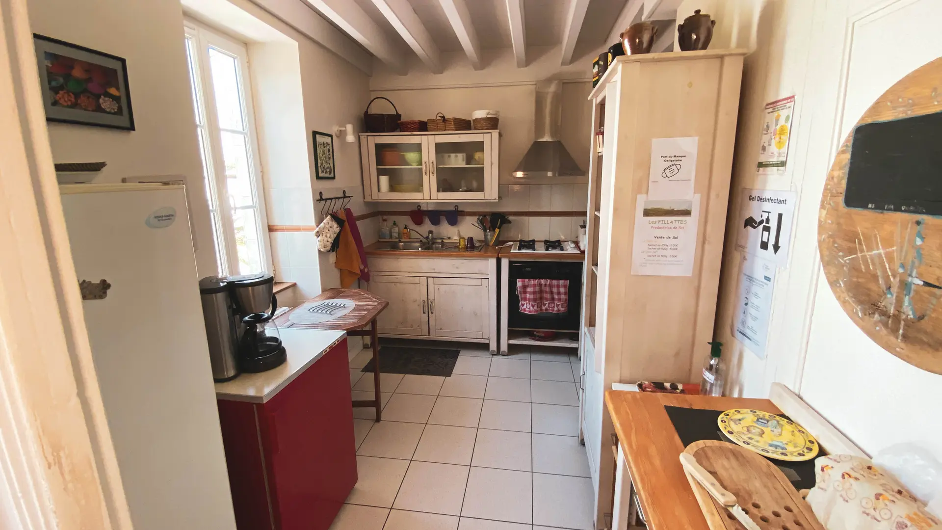 L'entrée de la cuisine toute équipée juste à gauche de la porte vitrée donnant sur la terrasse carrelée des Fillattes