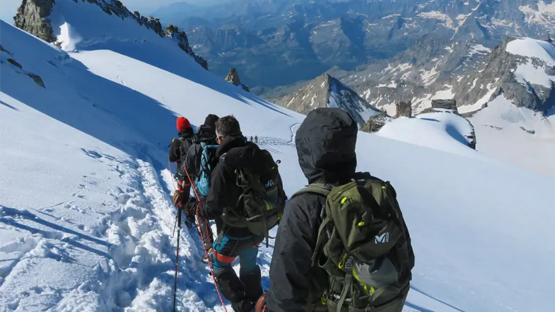 Alpinistes encordés descendant d'un sommet enneigé
