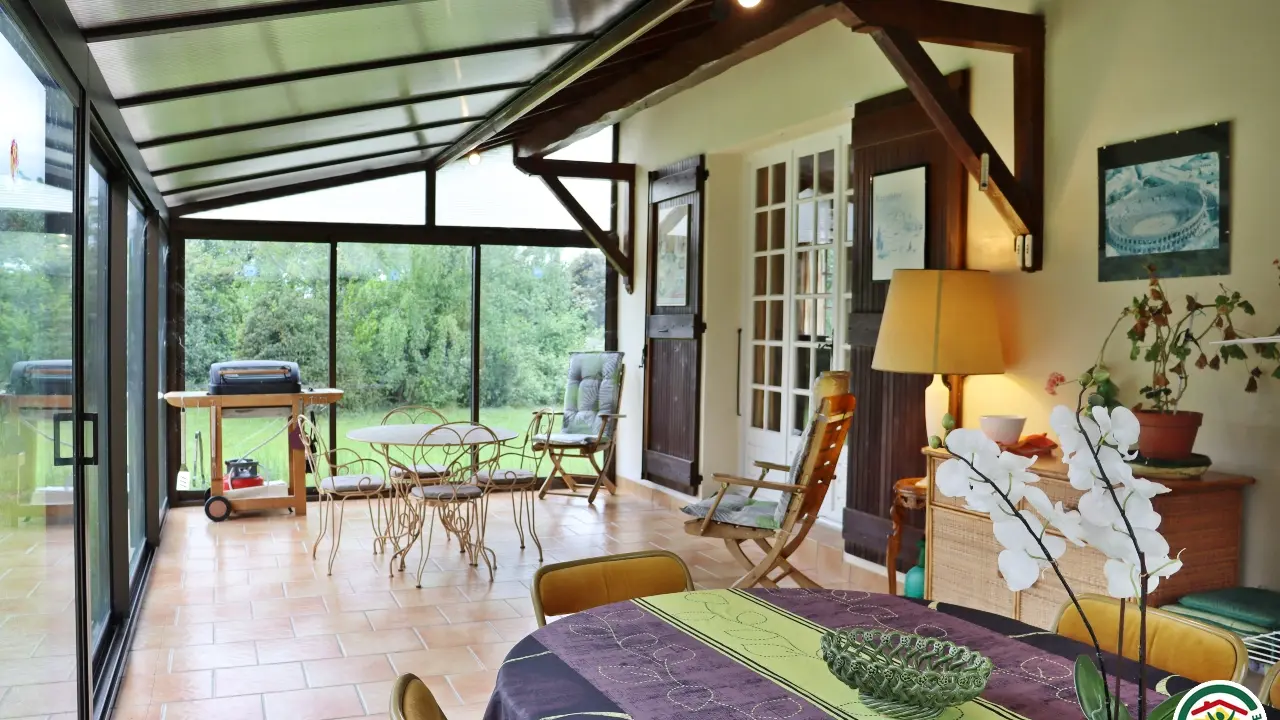 Véranda Jardin d'hiver avec coin repas et coin détente.