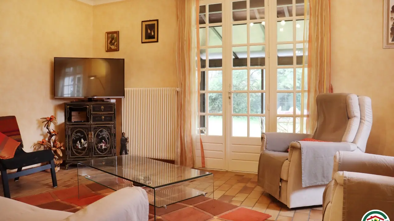 Séjour dotée d'un espace repas et d'un coin salon, TV