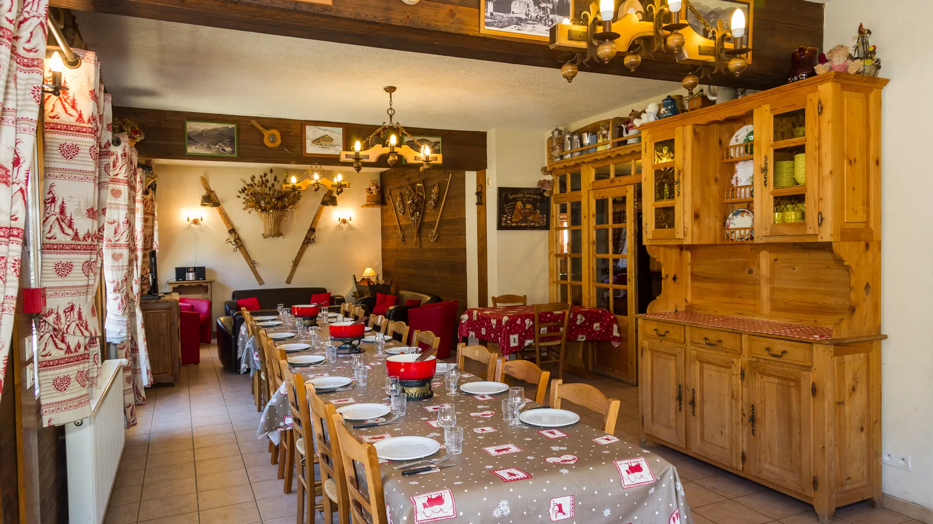 Salle à manger, table préparée pour une bonne fondue, coin salon au fond