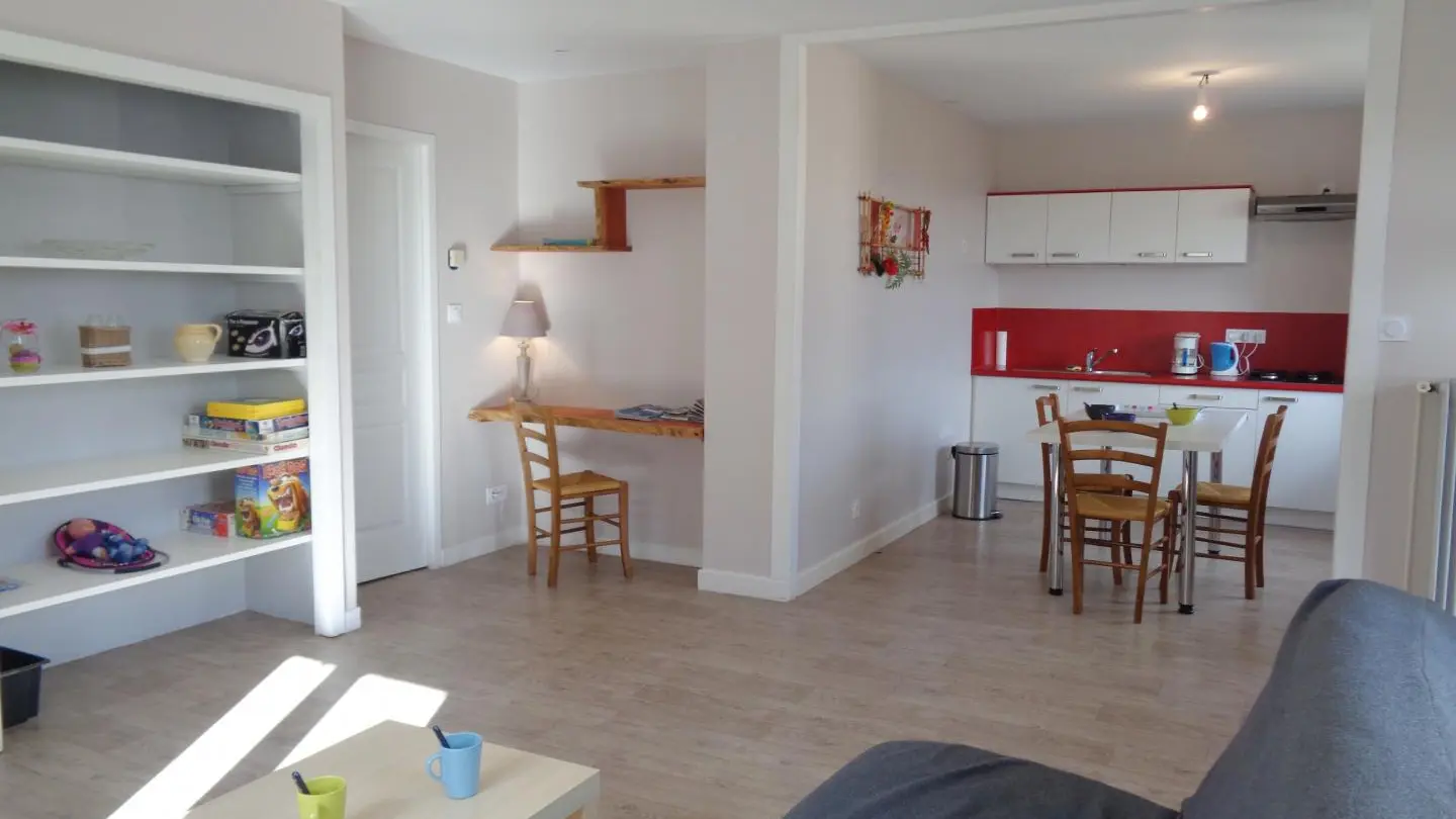 Pièce à vivre avec cuisine équipée ouverte sur le salon.