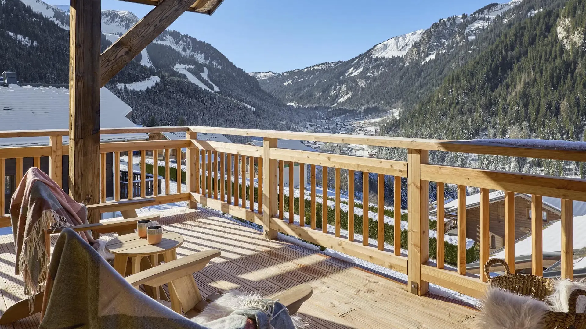 Terrasse couverte avec mobilier de jardin, vue sur les montagnes enneigées