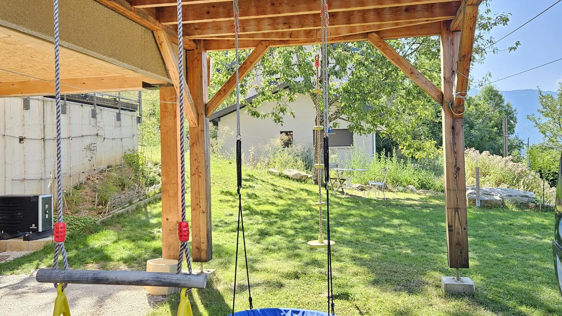 Balançoires pour enfant accrochées sur la terrasse en bois.