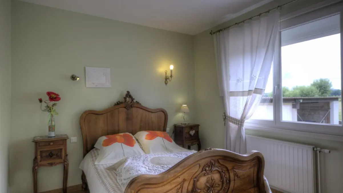 chambre aux coquelicots avec lit 2 personnes et fenêtre donnant sur la cour .