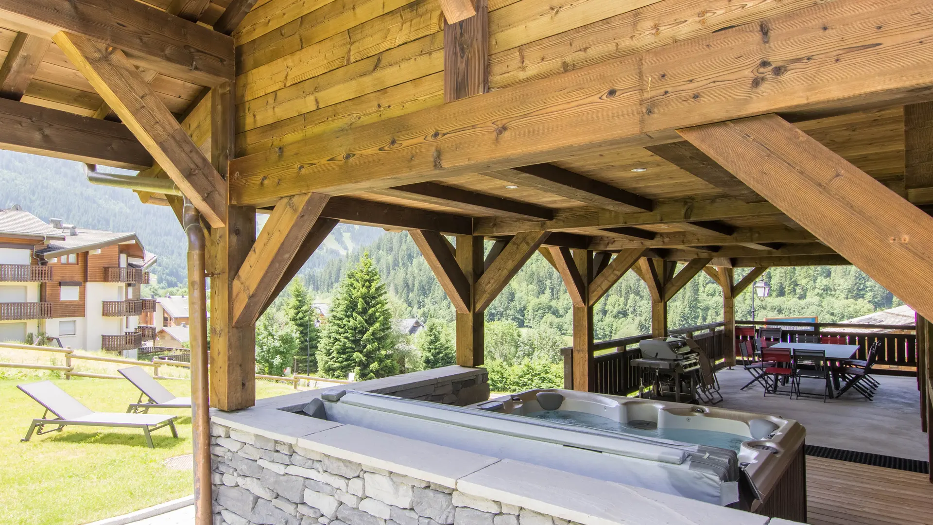 Terrasse couverte avec bain à remouds, barbecue et espace repas