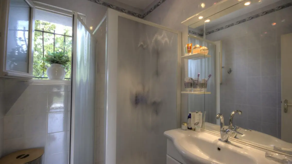 salle de bain avec grande douche de 90 cms et sa fenêtre .