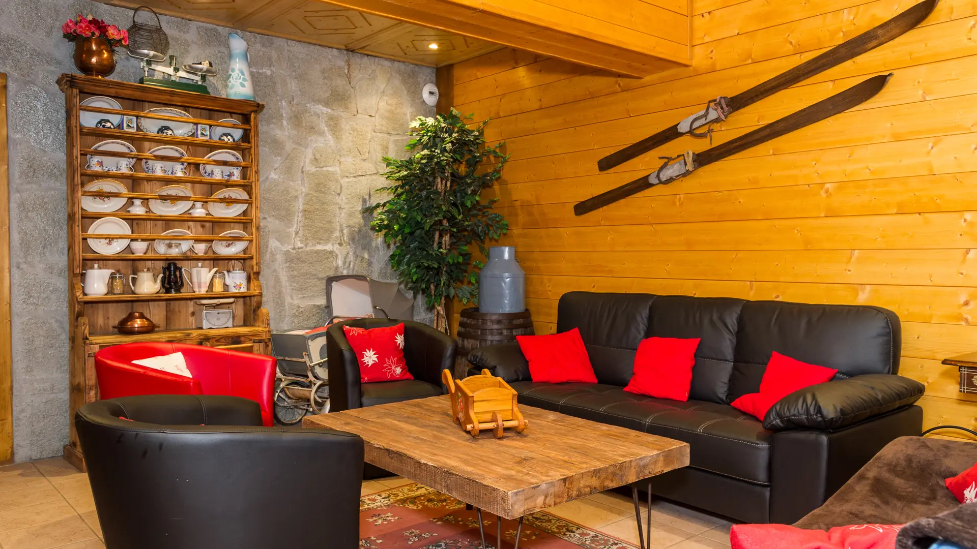 Salon confortable avec joli vaisselier et vieux skis en bois pour la décoration