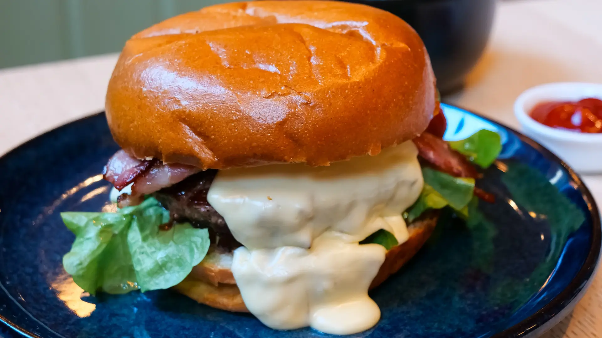 Burger Angus au reblochon, bacon, oignon  confit, salade et frites
