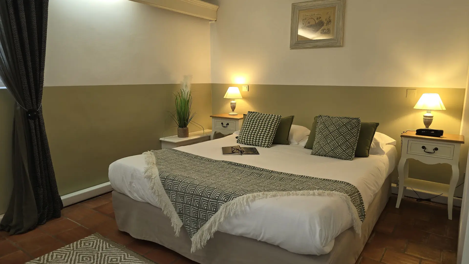 Une chambre au style provençal avec poutres apparentes, sol en terre cuite et ambiance cosy.