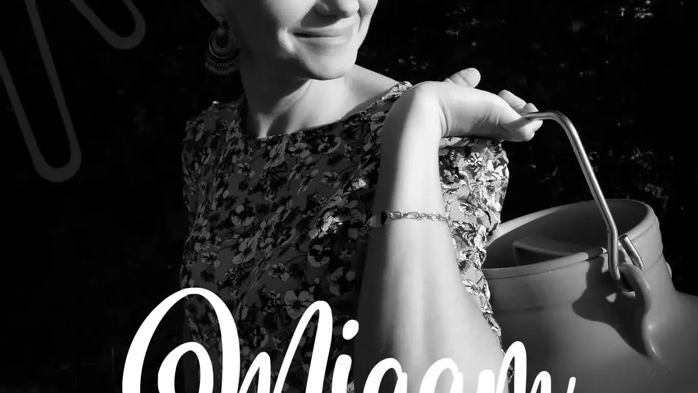 Une femme souriante porte un bidon de lait.