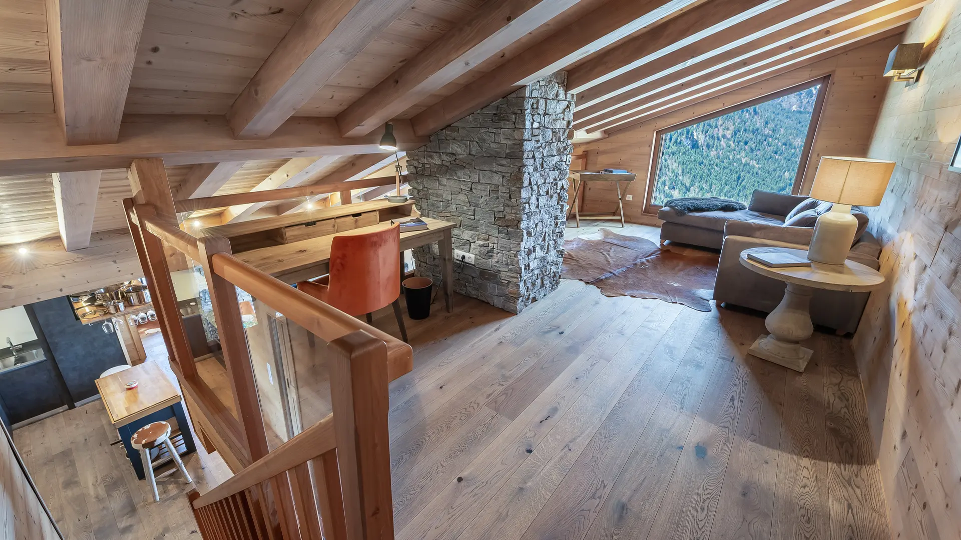 Espace détente avec coin bureau, canapé, fenêtre, vue montagne