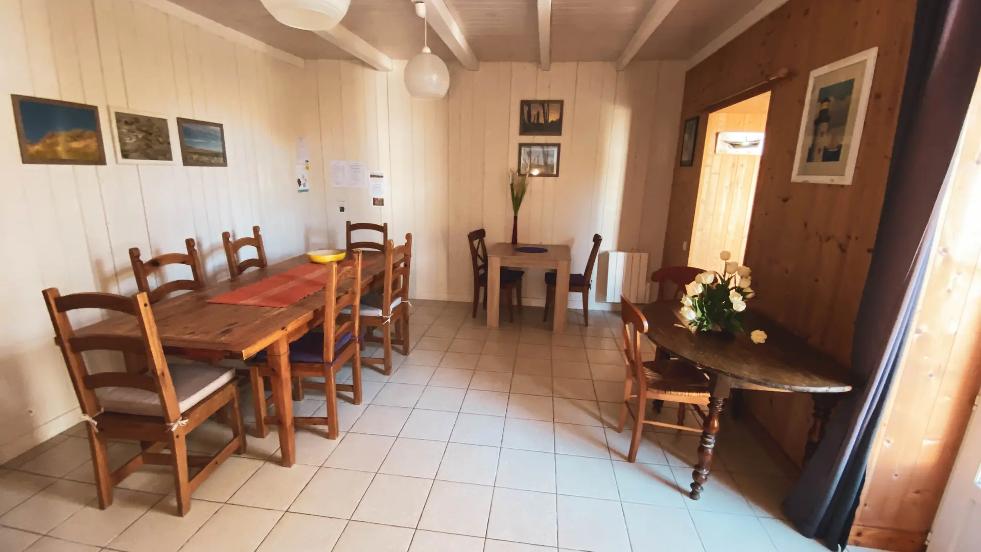 L'entrée de la grande salle à manger située à gauche du couloir principal d'entrée des Fillattes avec ses 3 tables pour toute la famille