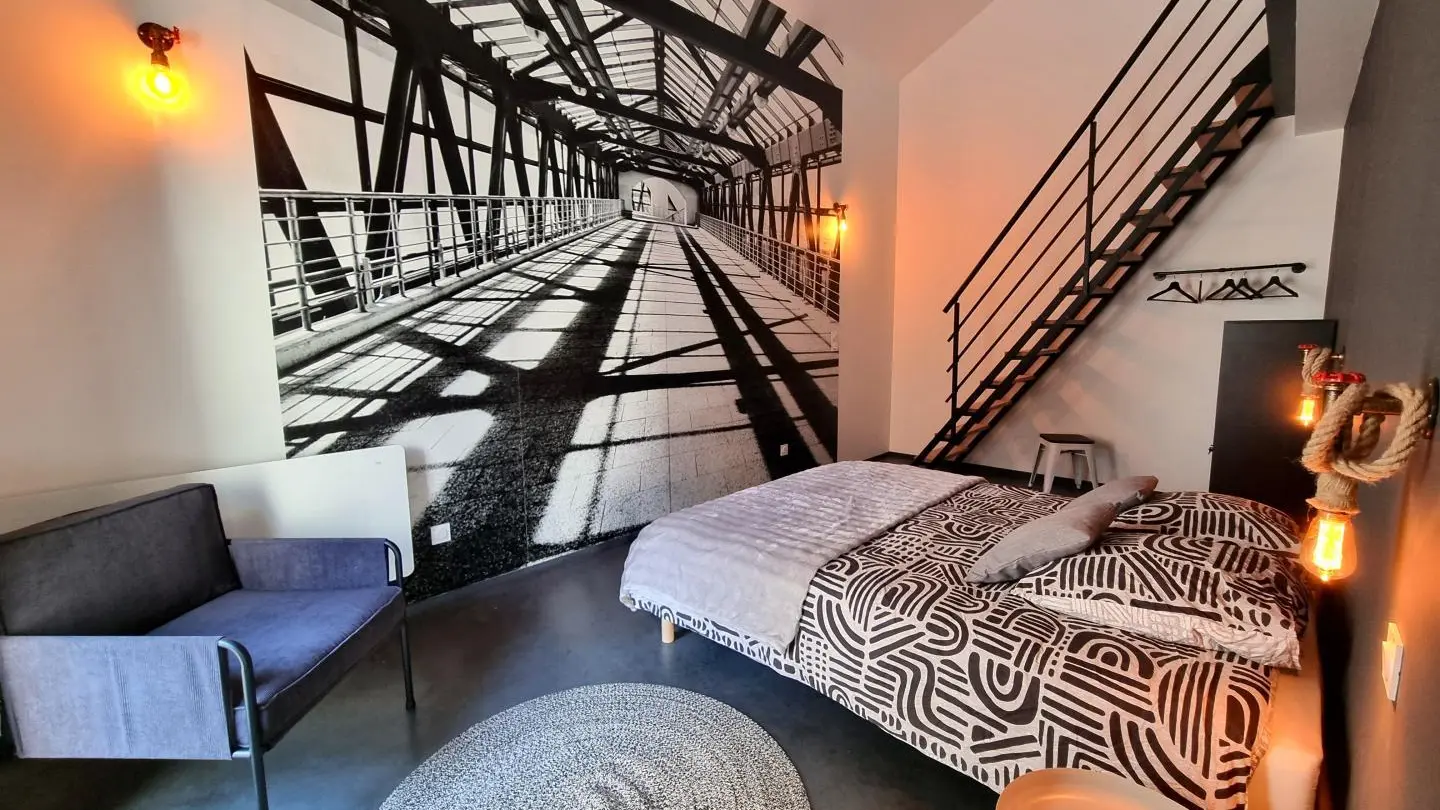 Chambre familiale High Line : un lit 160x200 et une mezzanine accessible par un escalier de meunier avec 2 lits 90 et un espace jeux & Tv avec un canapé convertible.