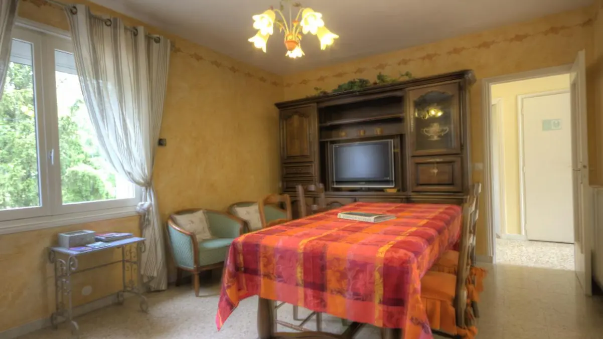 salle à manger , salon  avec 2 fenêtres ,
canapé ,fauteuil ,bridge ,télé .