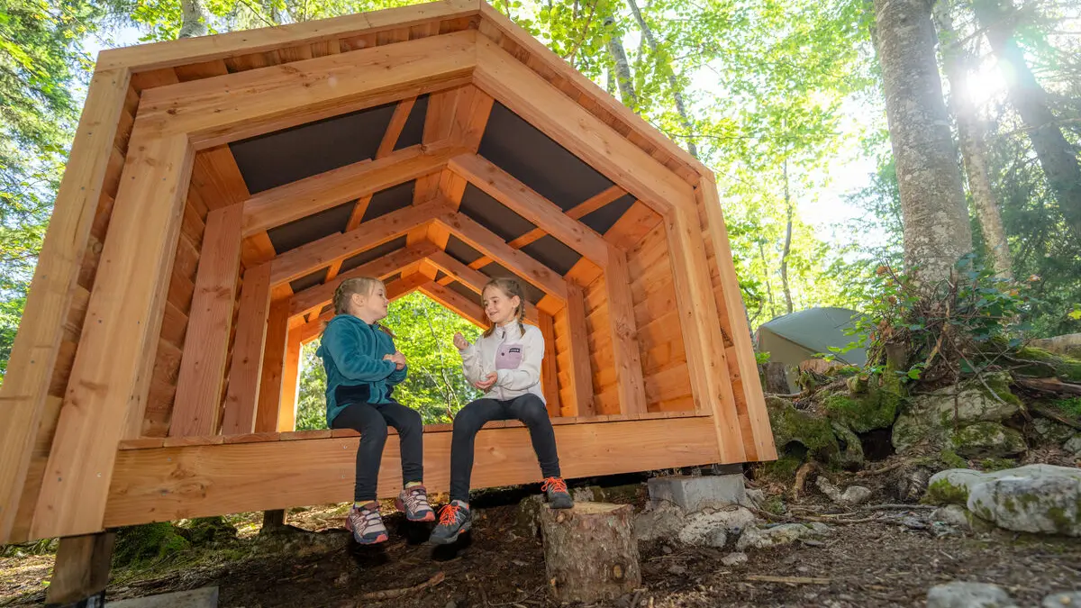 Enfants assis dans le shelter (abri en bois).