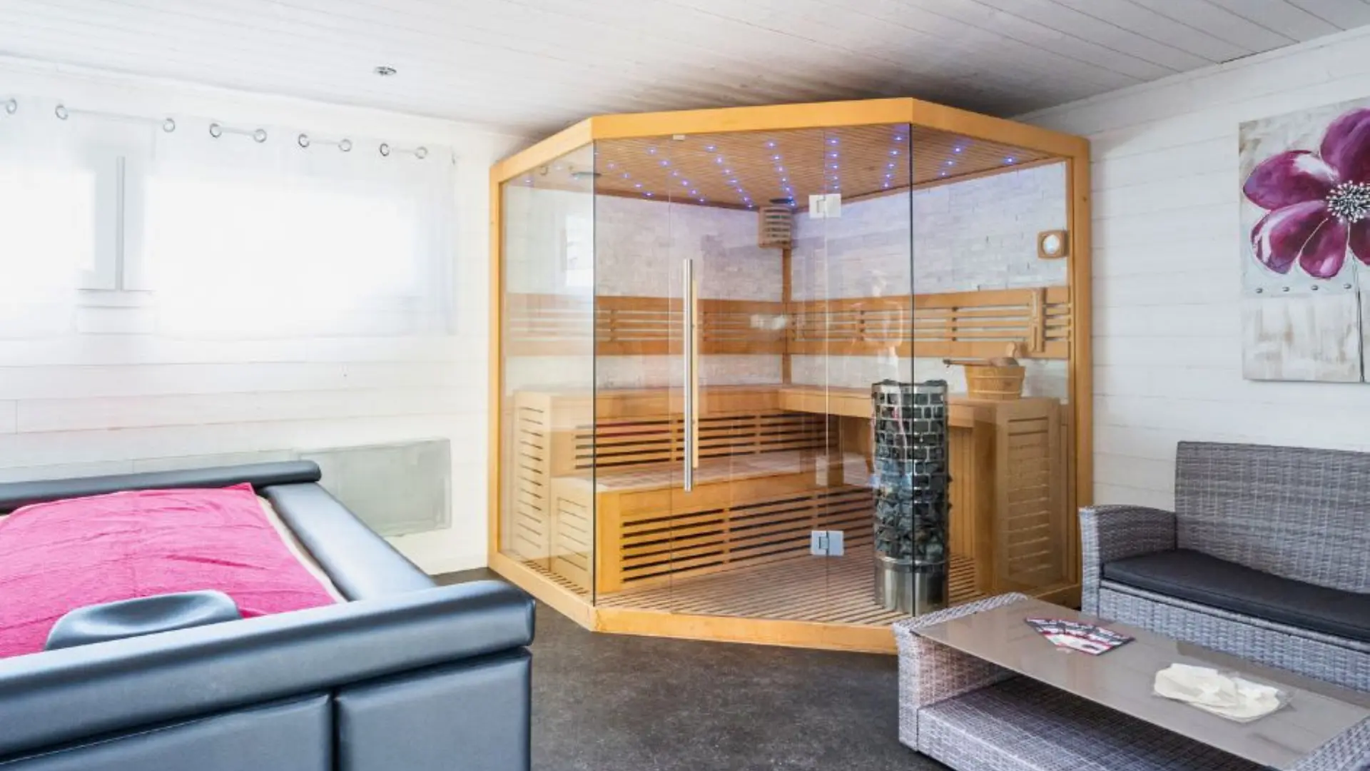 intérieur de l'espace n=bien-être avec le saune et la table relaxante et un espace canapé sur la droite