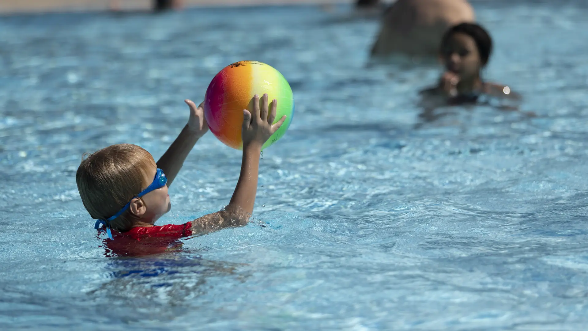Enfant jouant au ballon dans l'eau
