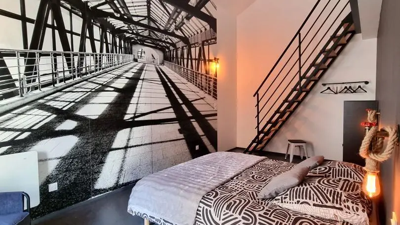 Chambre familiale High Line : un lit 160x200 et une mezzanine accessible par un escalier de meunier avec 2 lits 90 et un espace jeux & Tv avec un canapé convertible.
