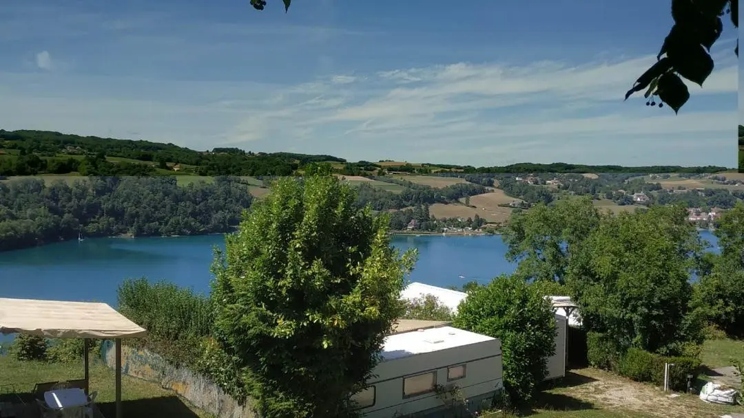 Photo prise depuis le Camping Bellevue avec vue sur des emplacement camping-car au premier plan et du lac de paladru au deuxieme plan