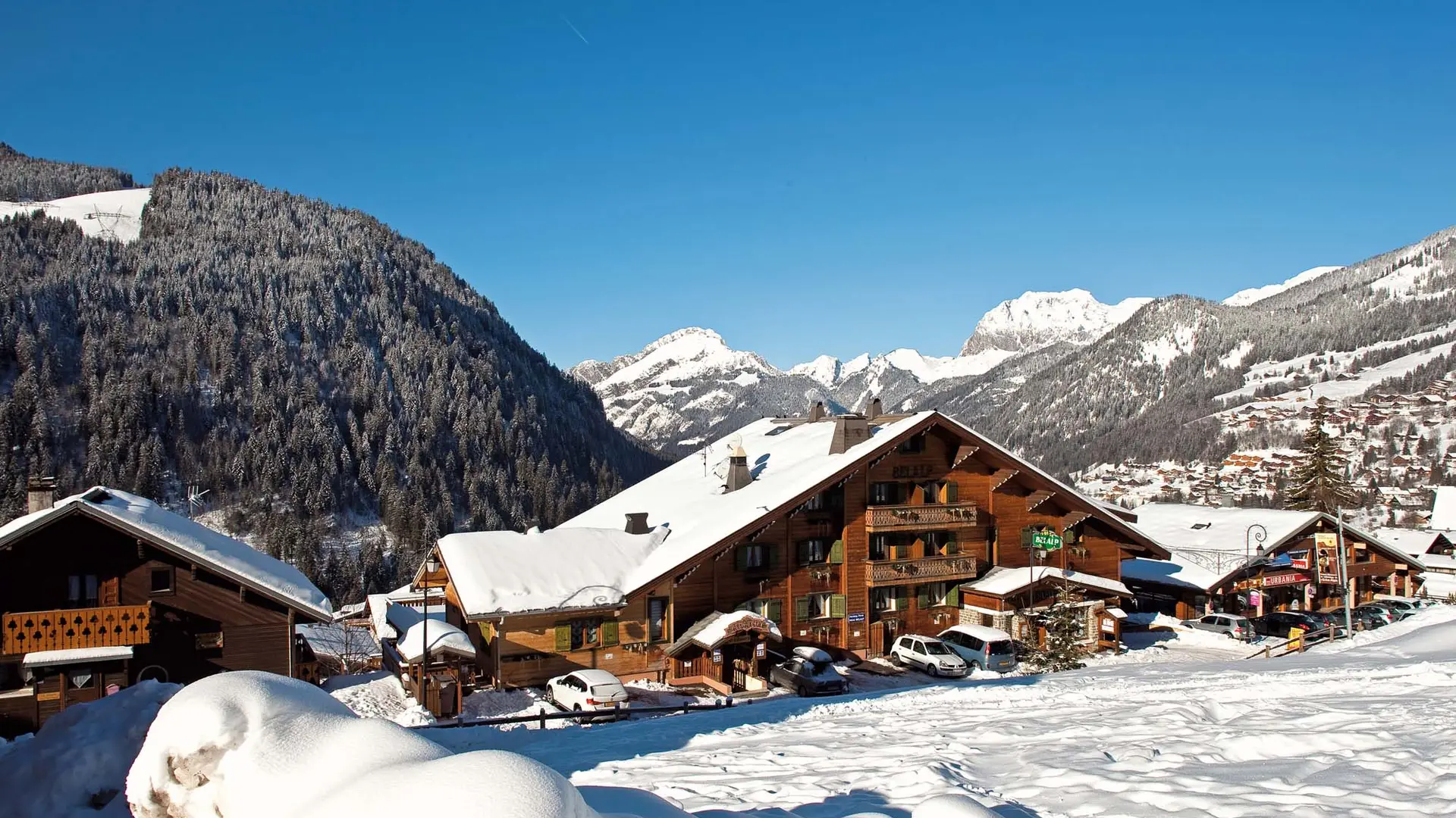 Vue de l'hôtel sous la neige avec les montagnes en arrière-plan