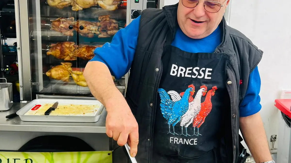 Joël Billet préparant le poulet de Bresse à la crème au marché Cerdon Cuivrerie en mars