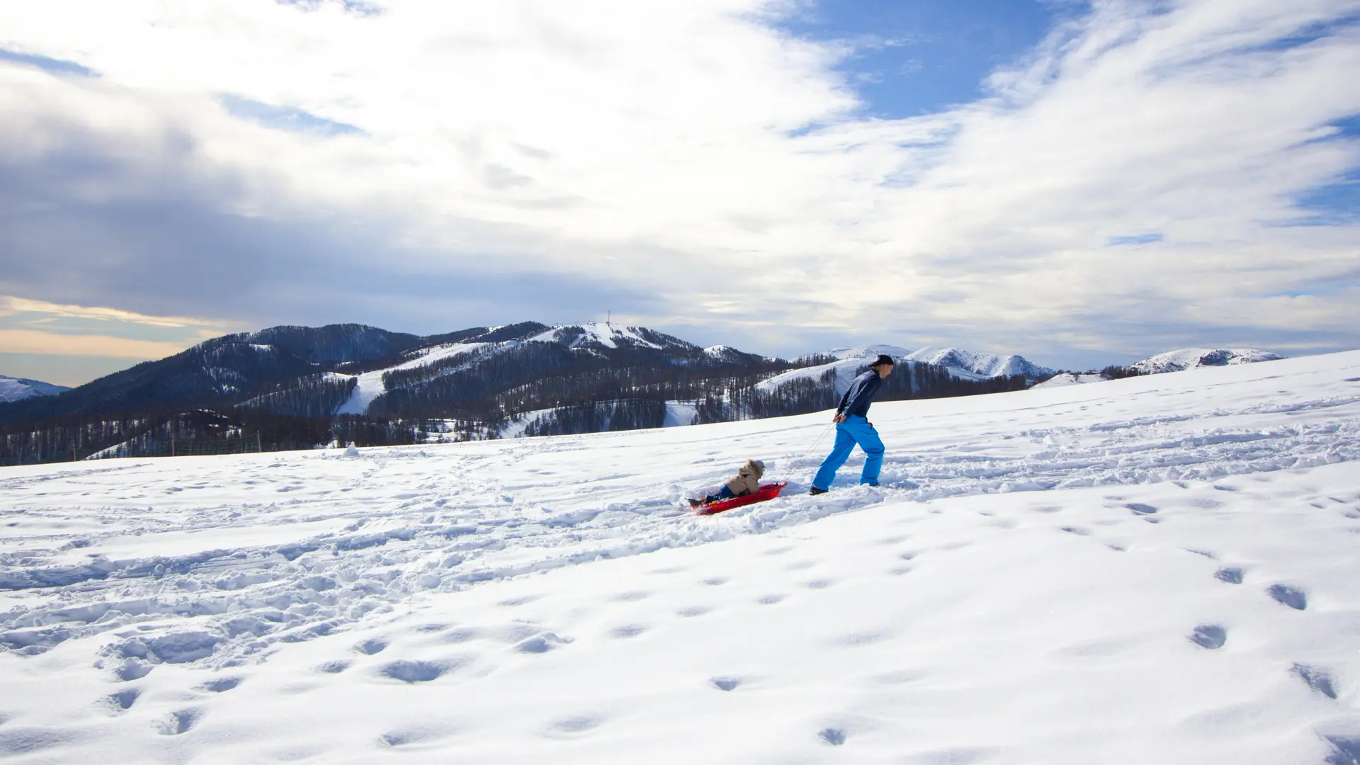 adulte remontant enfant dans luge