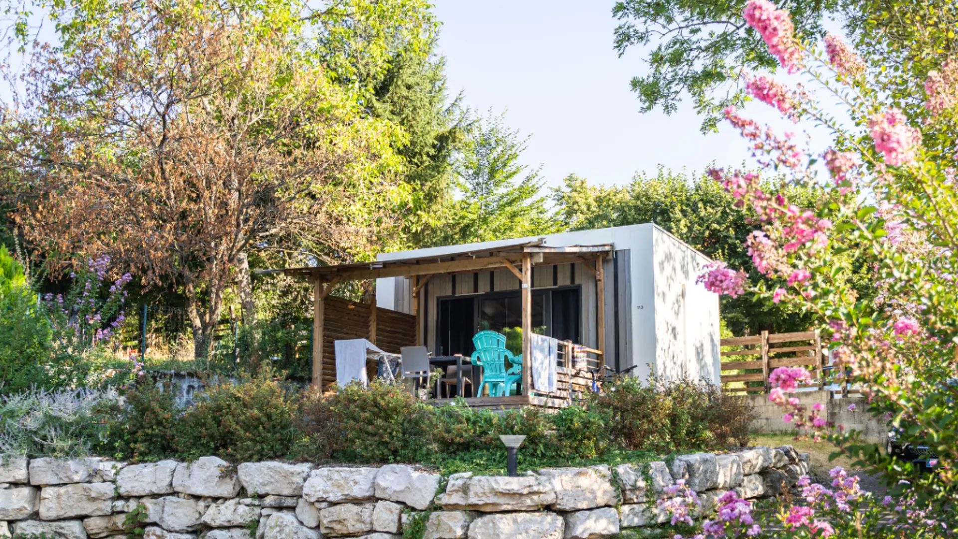 mobilhome entouré de verdure et de fleurs