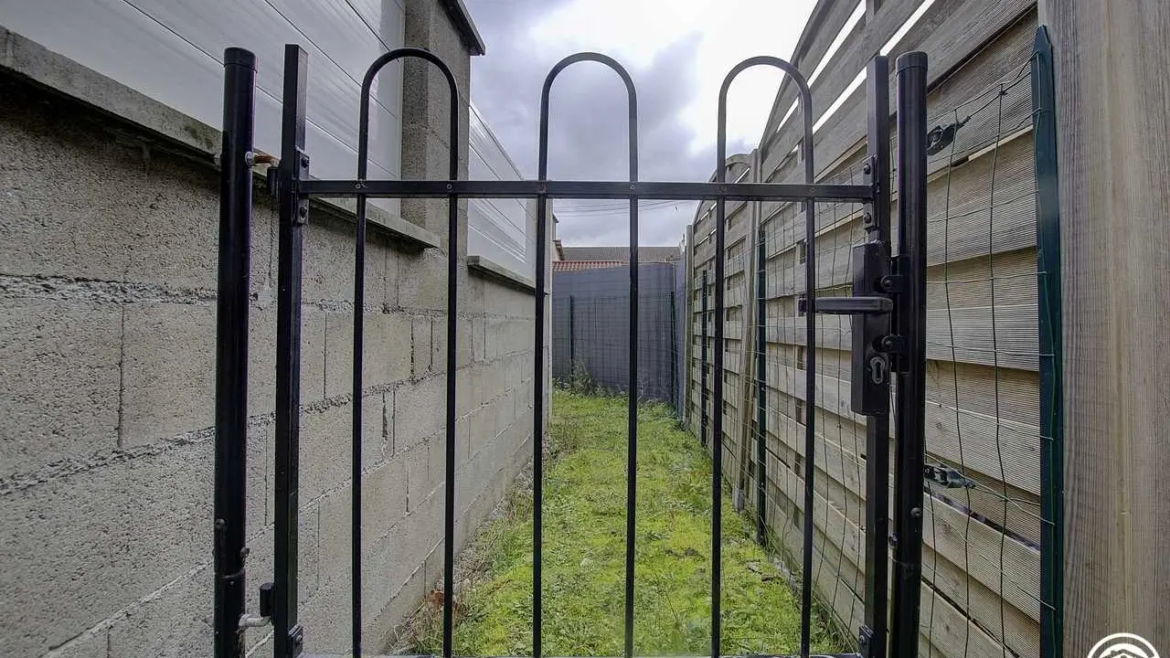 Le passage entre la place de parking privée et l'accès à la cour du gîte