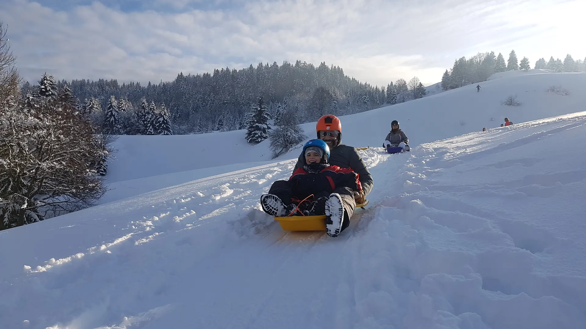 Famille descente en luge à neige dans les alpages
