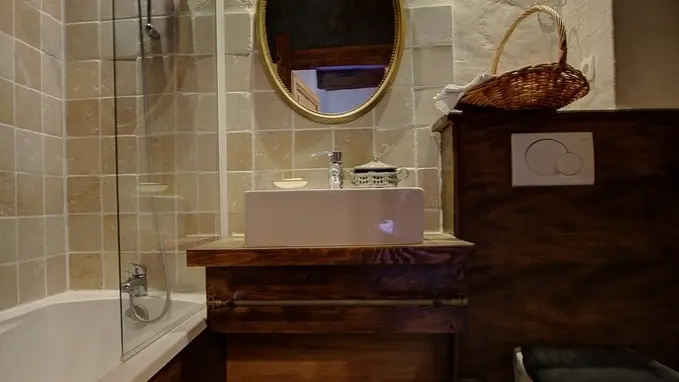Salle de bain avec baignoire et wc avec plafond à la française.