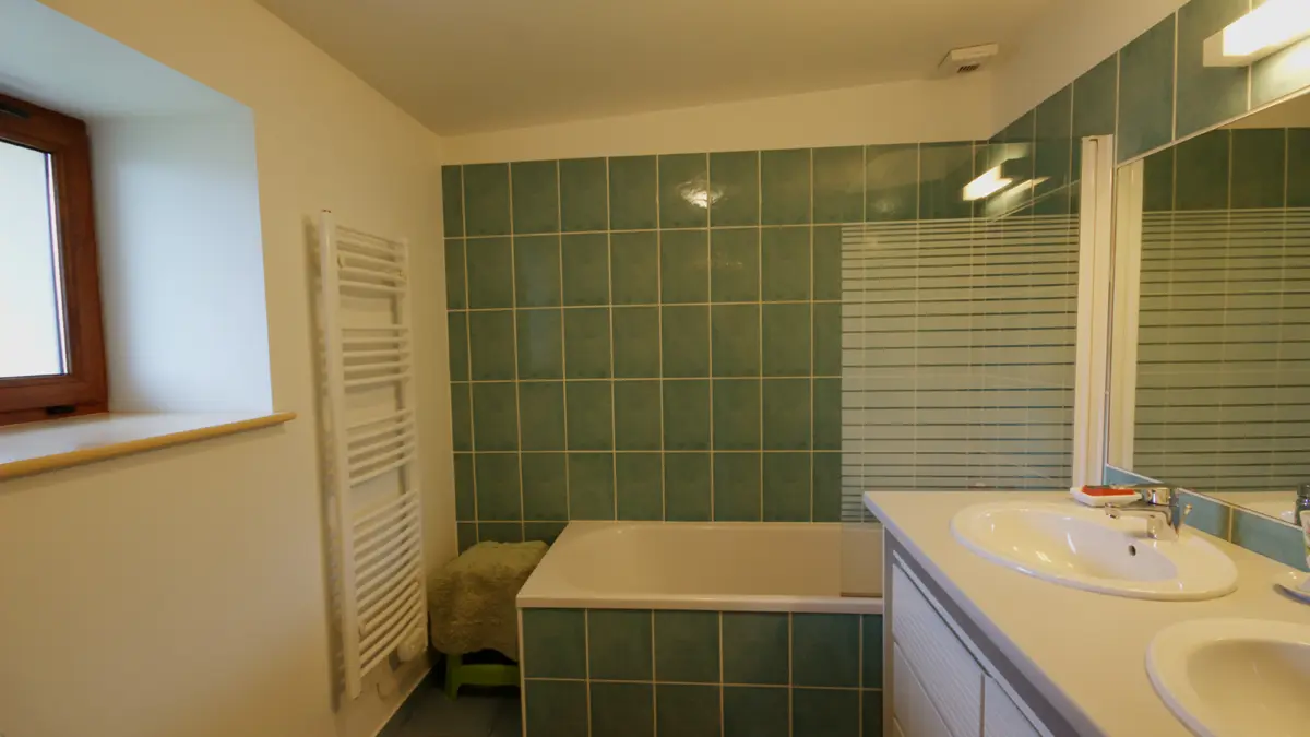 Salle d'eau avec douche et baignoire à l'étage.