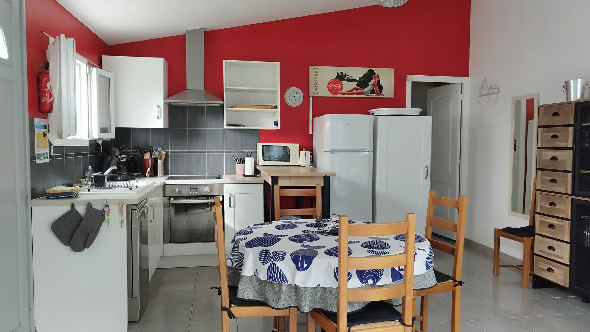 La cuisine tout équipée ouverte avec table ronde et quatre chaises.