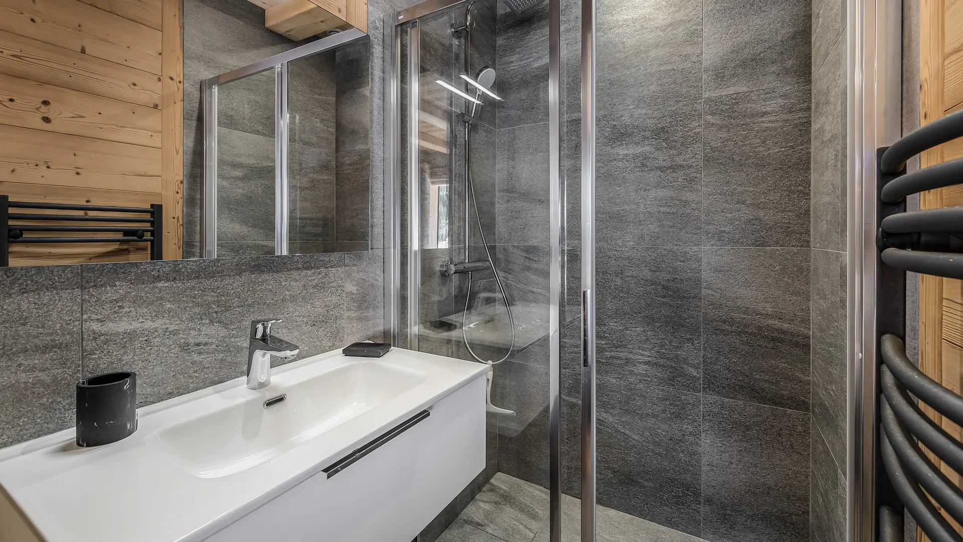 Salle de bains avec douche à l'italienne, grande vasque avec meuble, miroir et sèche serviettes