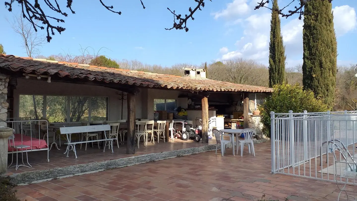 Abri piscine avec salle à manger et coin plancha