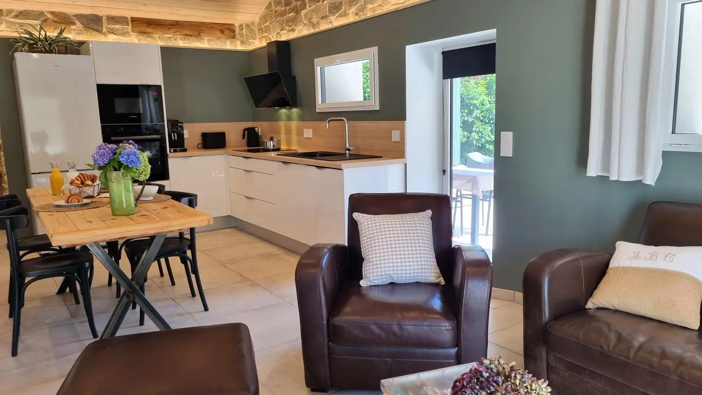 Séjour lumineux avec cuisine, salle à manger et salon détente.