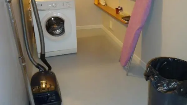 Cellier côté cuisine avec lave-linge et nécessaire ménage